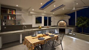 A modern kitchen with a dining area, built-in shelves, and a large window. - Luxury apt With Roofed Patio Near Beach & Center (Split)