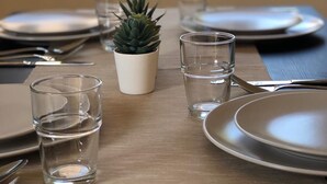 A dining table set with plates, cutlery, and glasses, with a small potted plant in the center. - beautiful place in the village (Elsteraue)