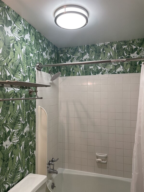 A bathroom with a shower, a toilet, and a sink.