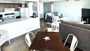 A modern living area with a kitchen, dining table, and seating. - Ocean & Bay Views, Resort Amenities, Weekly Activities & Fireworks! - Book Now (Ocean City)
