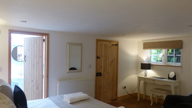 A bedroom with a bed, a desk, a chair, a mirror, and a window. - Idyllic rural retreat - Generous ferry discounts available (Isle of Wight)