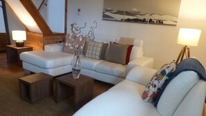A modern living room with a white sofa, a coffee table, and a lamp. - Idyllic rural retreat - Generous ferry discounts available (Isle of Wight)