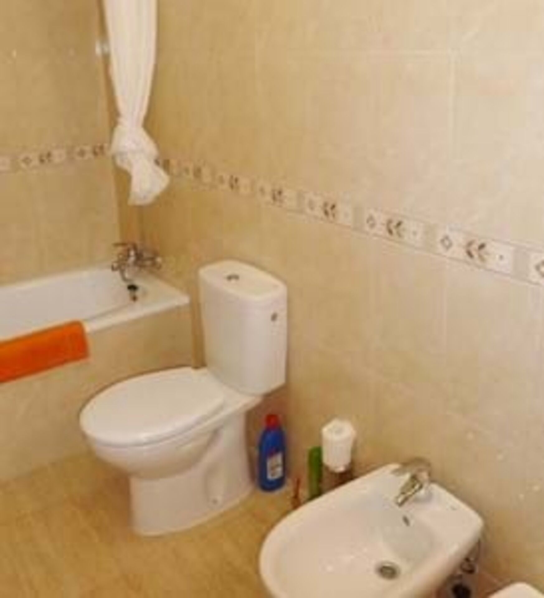 A bathroom with a toilet, bidet, and sink.