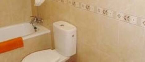A bathroom with a toilet, bidet, and sink.