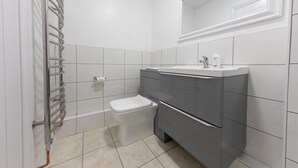 A bathroom with a toilet, sink, and mirror.