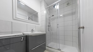 A modern bathroom with a glass-enclosed shower, a vanity with a mirror, and a toilet. - Platform Holderness House (Hull)