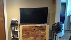 Ein Fernseher im Kellerraum mit Playstation 3, Netflix und Kabelanschluss.