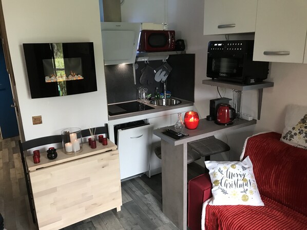 A compact kitchenette with a microwave, coffee maker, and a small refrigerator.