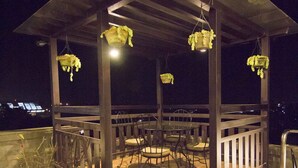 An outdoor patio with a wooden pergola, seating area, and potted plants. - Summit Residency Airport Hotel (Kathmandu)