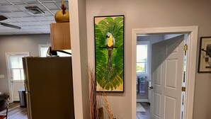 Amplia sala de estar con un mueble de madera grande, un tapete decorativo y un cuadro colgado en la pared de un loro.