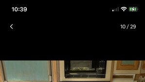 Une cuisine de taille réduite, équipée d’une cuisinière, d’un four à micro-ondes et d’un évier.
