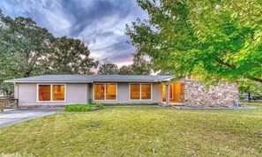 Stylish single-story home with a central entrance and well-manicured lawn.