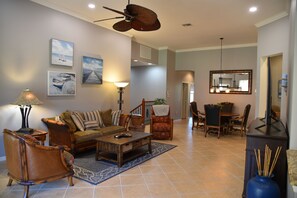 A spacious living room with a sofa, armchairs, a coffee table, and a dining area with a table and chairs. - Newly remodeled coach home & golf membership in Vasari Country Club. (Bonita Springs)