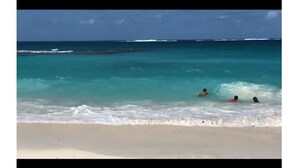 Een strand met helder turquoise water en een zandstrand.