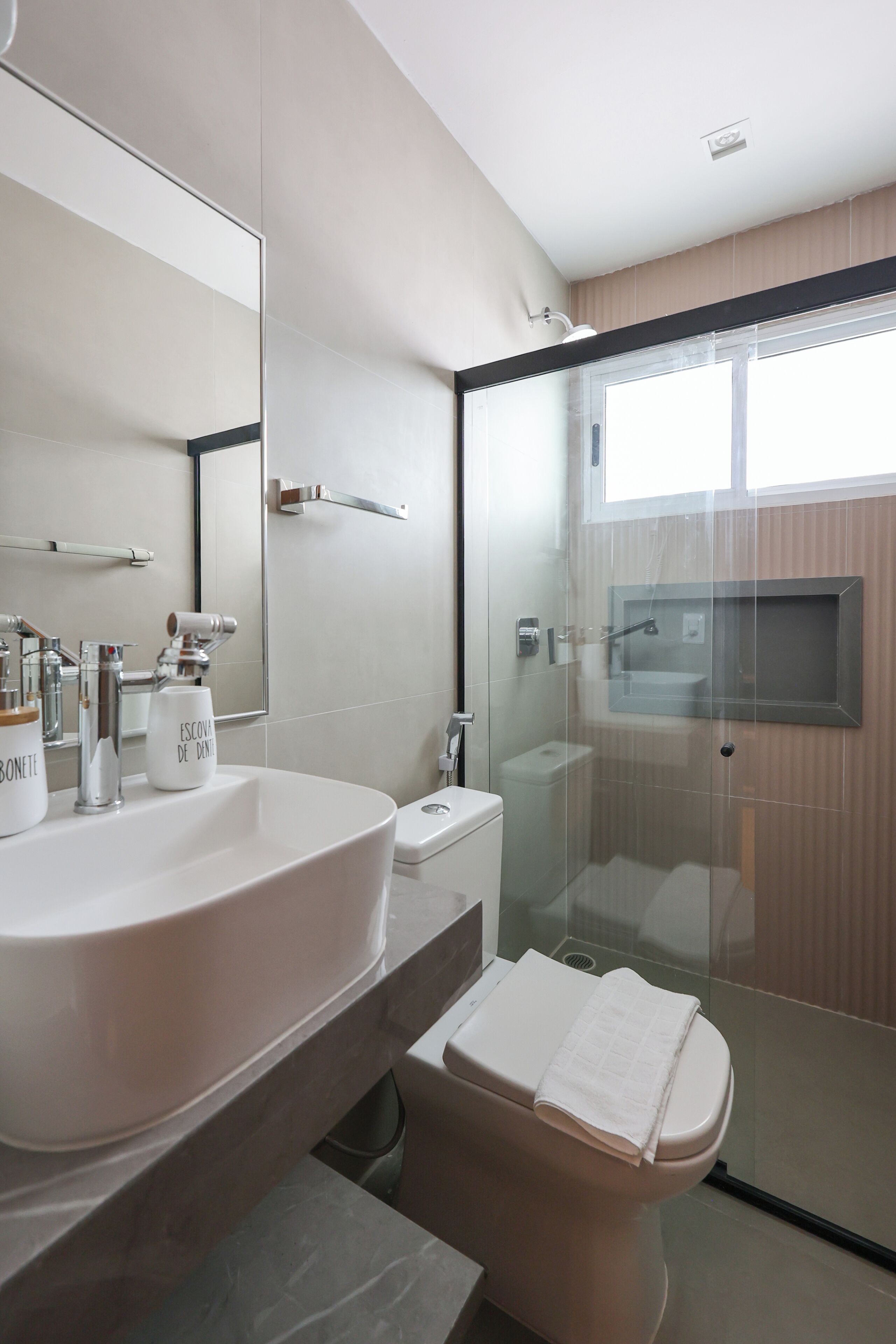 Une salle de bain moderne avec un grand lavabo, des toilettes et une douche à parois de verre.