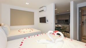 Une chambre d’hôtel équipée d’un lit, d’une télévision, d’une kitchenette et d’un coin repas.