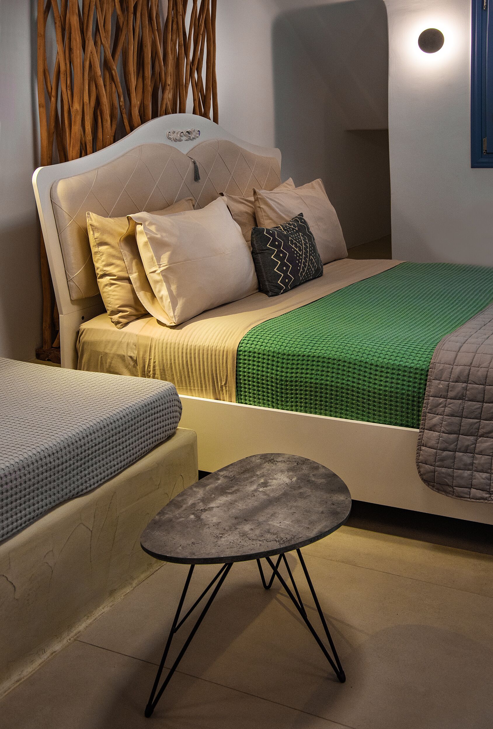 A bedroom with a bed, a small table, and a decorative wall.