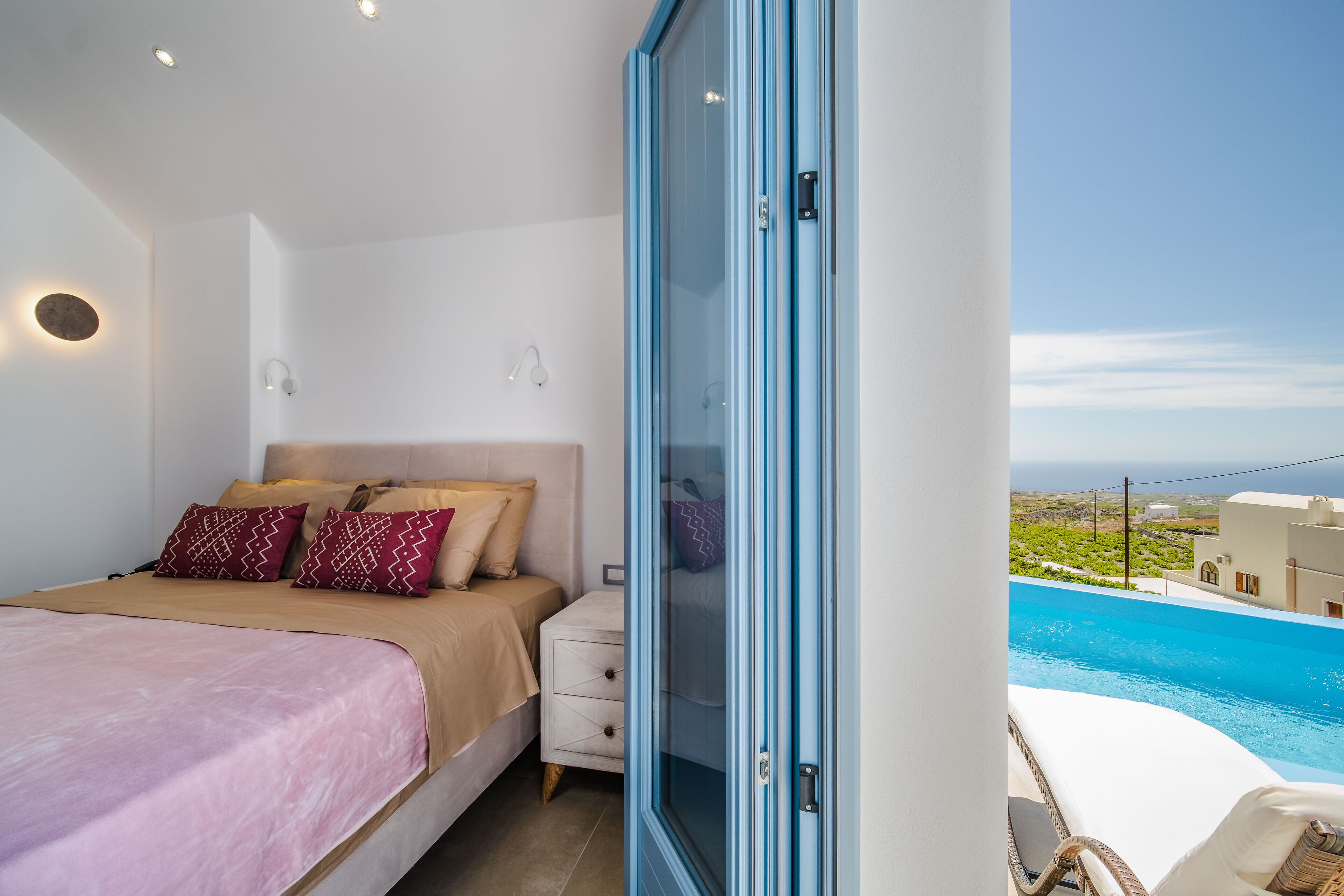 A bedroom with a bed, nightstand, and a view of a swimming pool.