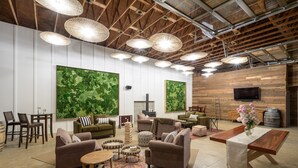 Un vaste espace salon doté de nombreux sièges, notamment des canapés et des fauteuils, disposés autour d’une table basse centrale. On y trouve également de grands téléviseurs fixés au mur et une cheminée.