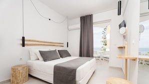 A modern bedroom with a bed, bedside table, and a view of the outdoors.