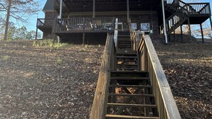 Une maison à deux étages dotée d’une terrasse en bois et d’un escalier menant à l’étage supérieur.