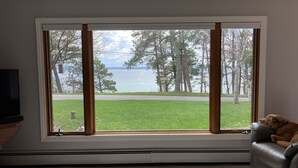 Une pièce dotée d’une grande fenêtre donnant sur un lac et des arbres.