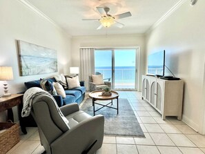 Relax in a spacious living room with a ceiling fan, ocean views, and a flat-screen TV.