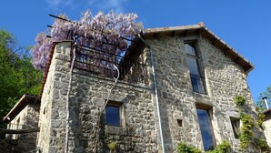 A stone building with multiple windows and a balcony. - Gite de Chapelèche les Glycines Pour 8 à 10 Personnes (Gluiras)