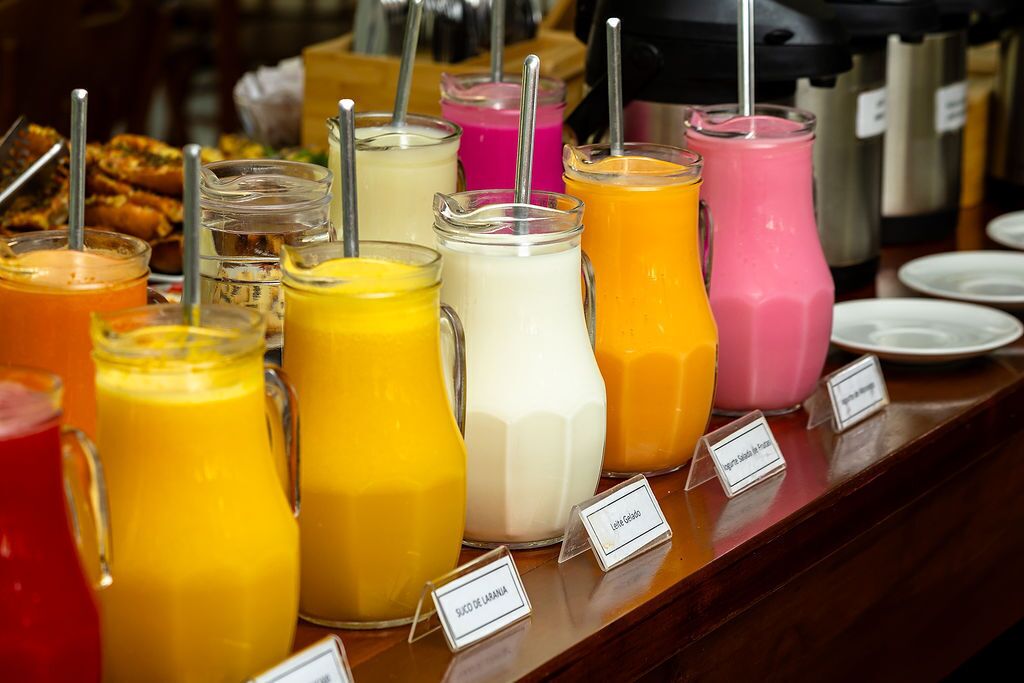 Une variété de smoothies colorés, présentés sur un comptoir, chacun étant accompagné d’une étiquette.