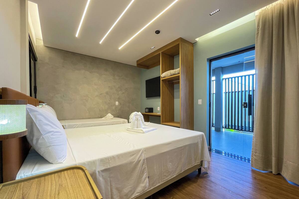 Ein Hotelzimmer mit Bett, Nachttisch und Fernseher.