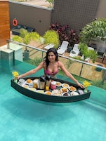 Una piscina al aire libre, sombrillas, sillones reclinables de piscina