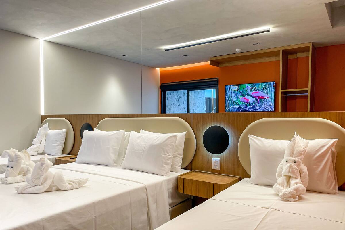 Ein Hotelzimmer mit zwei Betten, einem Fernseher und einer wandmontierten Steuerung.