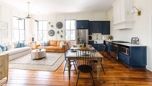 A modern kitchen with dark cabinets, a stainless steel refrigerator, and a built-in oven. - Guesthouse Charleston: EAST (46 H) (Charleston)