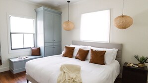 Ein Schlafzimmer mit einem großen Bett, einem Fenster, einem eingebauten Kleiderschrank und einem Nachttisch.