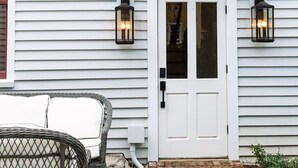 A white house with a front door labeled "No 46 DEFG." Two wall-mounted lanterns are on either side of the door. - EAST 46 G - 1 Block to King! (Charleston)
