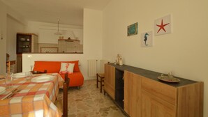 A compact kitchen with a dining area, featuring a tiled backsplash, wooden cabinets, and a small island with a sink. - Awesome apartment in Contrada Fiori Sud (Contrada Fiori Sud)