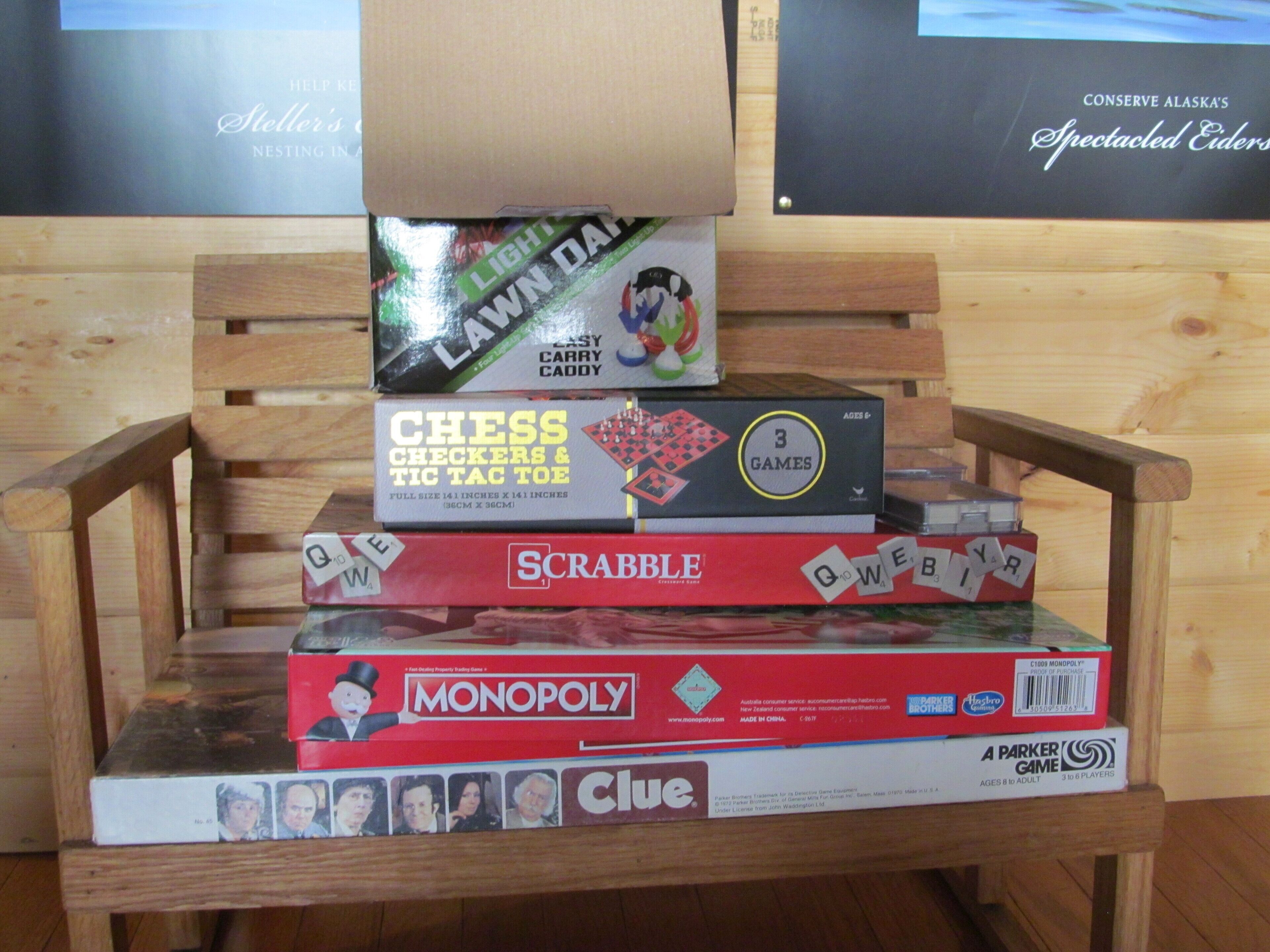 A wooden chair with a stack of board games on it.