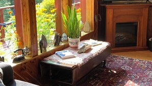 Una sala de estar acogedora con chimenea, un sofá, una mesa de centro y un televisor.