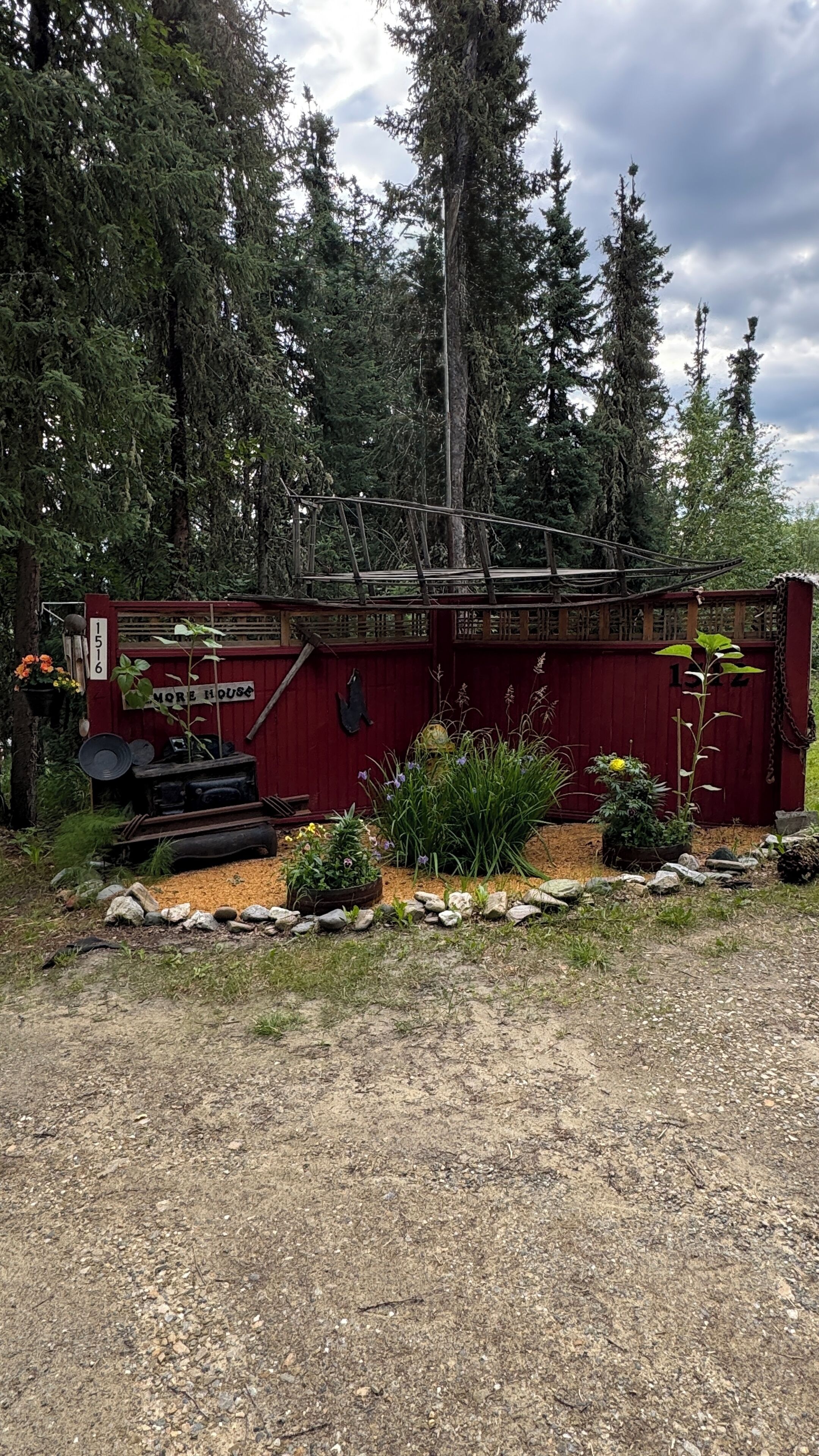 A rustic wooden structure with a red door labeled '1516 More House'.