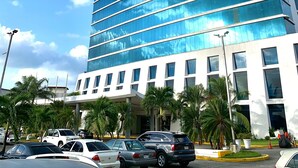 A modern hotel with a prominent 'SAND DIAMOND' sign, featuring a glass facade and a white lower section.