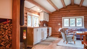 A cozy log cabin interior with a kitchen, dining area, and a fireplace. - Nice home in Kvam with kitchen (Kvam)