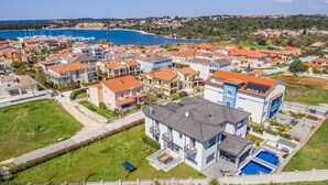 A residential area with modern houses, a swimming pool, and a marina in the background. - Stunning home in Banjole (Banjole)