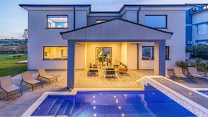 A modern house with a swimming pool, outdoor seating, and a covered patio area. - Stunning home in Banjole (Banjole)