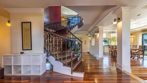A spacious interior with a wooden staircase, a dining area, and a kitchen visible in the background. - Stunning home in Banjole (Banjole)