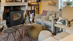 Una sala de estar acogedora con chimenea, un sofá, una mesita de centro y un tapete estampado.