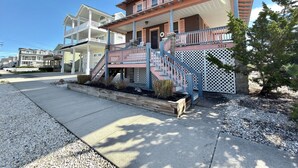 A two-story building with a balcony, a wooden deck, and a stone wall.
