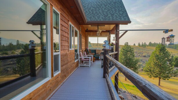 A wooden deck with outdoor seating and a view of the landscape. - THE BIRDHOUSE,... Quiet Country Home in the Bitterroot Valley. (Florence)