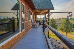 Eine Holzterrasse mit Sitzgelegenheiten und Blick auf die Landschaft.