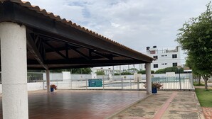 A covered outdoor area with tiled flooring and a metal fence. - Hostal Lucy (Valledupar)