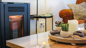 Un saló modern amb un moble de televisió negre, una taula de centre de fusta i una petita taula auxiliar amb objectes decoratius.